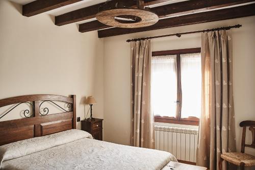 um quarto com uma cama e uma grande janela em Casa Rural El Cantueso em Hontanar