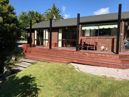 a home with a large wooden deck with a table at Middle Park Motel in Blenheim