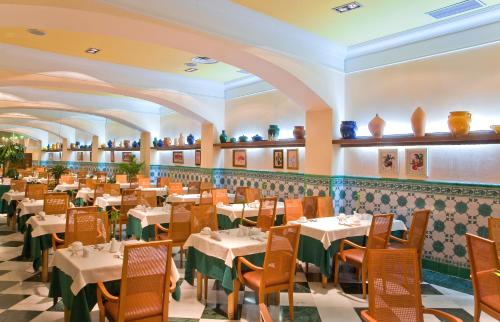 a restaurant with tables and chairs in a room at Senator Cádiz in Cádiz