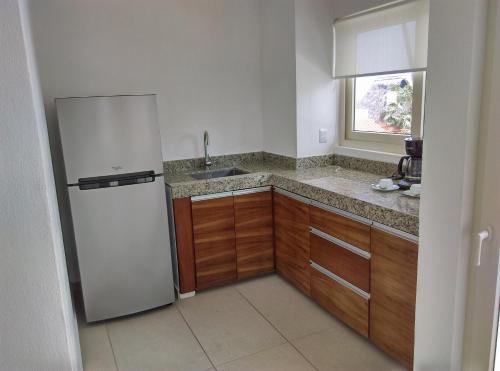 a kitchen with a refrigerator and a sink at Casablanca Resort  in Rincon de Guayabitos
