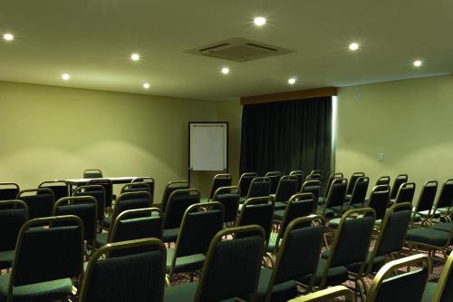an empty conference room with chairs and a screen at Nobile Inn Jundiaí in Jundiaí