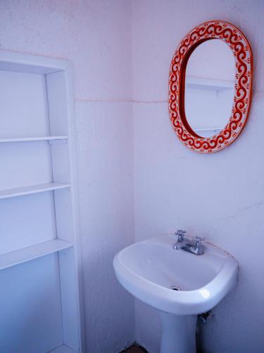 a bathroom with a sink and a mirror on the wall at Hostel Hospedarte Centro in Guadalajara