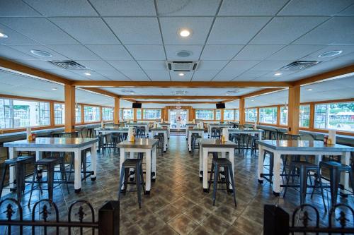 - une salle à manger avec des tables, des chaises et des fenêtres dans l'établissement Bethpage Two-Bedroom Cottage 4, à Urbanna