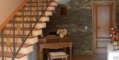 a living room with a staircase with a fireplace at Kira's Boutique Hotel in Mindelo