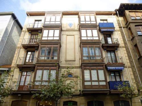 un edificio alto con ventanas y un reloj en él en Pension Areeta, en Getxo