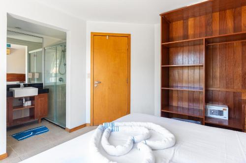 a bedroom with a white bed with a bath room at Cumbuco Dream Village Duplex with 3 bedrooms in Cumbuco