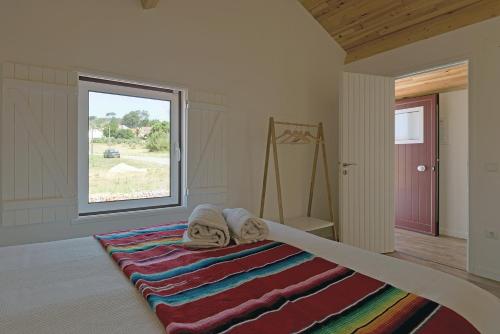 een slaapkamer met een bed met een kleurrijk tapijt bij Avó Rosa Guesthouse in São João da Ribeira