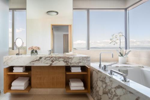 a bathroom with a large marble sink and a tub at Four Seasons Hotel Seattle in Seattle