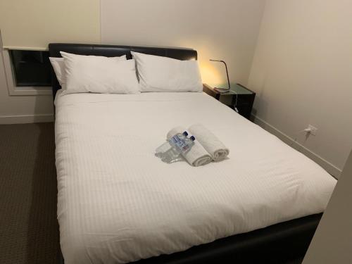 a white bed with a camera and a phone on it at Holiday Rental 6 KING BD 12PPL in Truganina