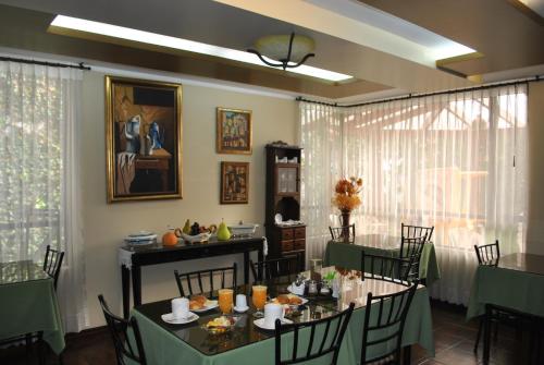 a dining room with two tables and chairs with food at MAK INN HOUSE in Latacunga