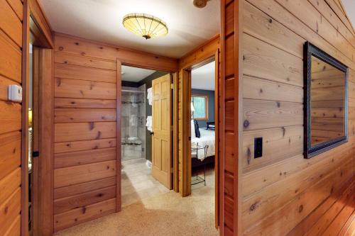 a hallway with wood paneled walls and a bedroom at Chanticleer Inn: Hudson House in Eagle River