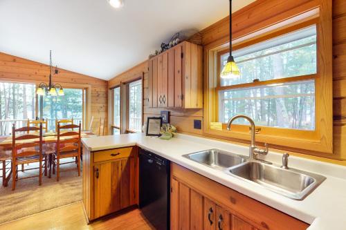 a kitchen with a sink and a dining room at Chanticleer Inn: Hudson House in Eagle River