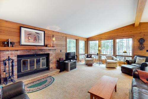 a living room with a fireplace and a tv at Chanticleer Inn: Hudson House in Eagle River