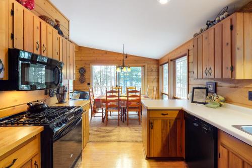 a kitchen with a stove and a dining room at Chanticleer Inn: Hudson House in Eagle River