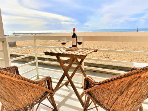 a table with two glasses of wine on the beach at House in beach- Oporto in Arcozelo