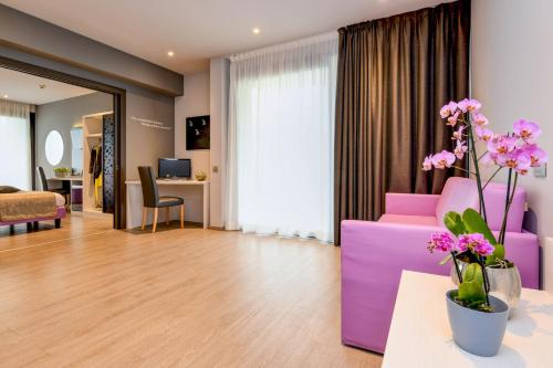 a living room with a purple couch and flowers at Hotel La Fiorita in Limone sul Garda