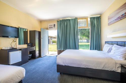 a hotel room with two beds and a television at Links Hotel in Adelaide