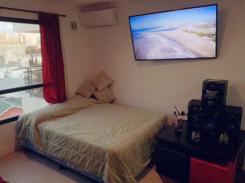 una camera da letto con un letto e una TV a schermo piatto di Edificio DOMUS a Necochea