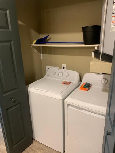 un pequeño lavadero con lavadora y secadora en Eagle's Den Suites Andrews a Travelodge by Wyndham en Andrews