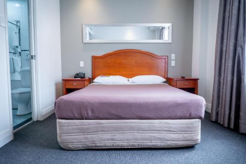 - une chambre avec un lit doté d'une tête de lit en bois dans l'établissement Great Southern Hotel Sydney, à Sydney