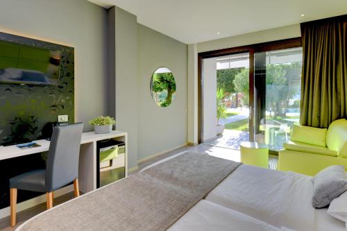 a bedroom with a bed and a desk and a chair at Hotel La Fiorita in Limone sul Garda