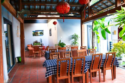 a patio with a table and chairs and a dining room at Daisy Garden Villa Hoi An in Hoi An