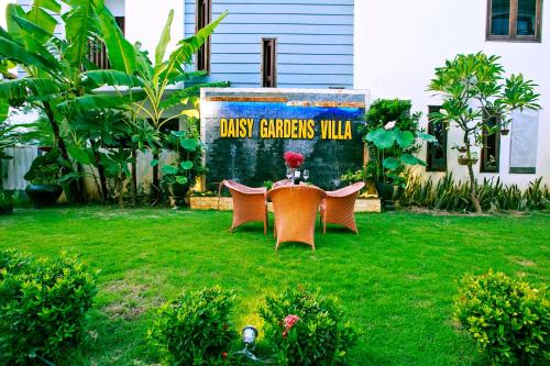 two chairs and a sign in a yard at Daisy Garden Villa Hoi An in Hoi An