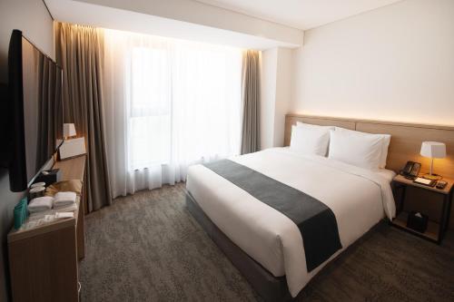 a hotel room with a large bed and a window at Orakai Daehakro Hotel, BW Signature Collection in Seoul