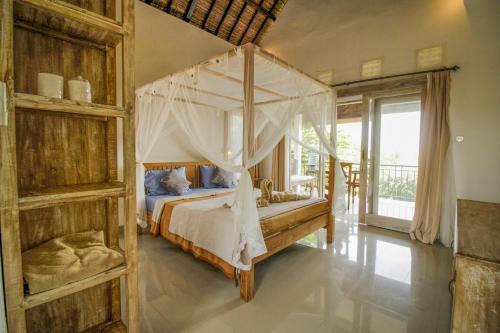 een slaapkamer met een hemelbed bij Namparan Villa in Ubud