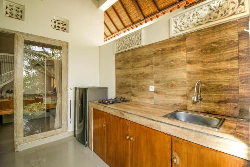 een keuken met een wastafel en een koelkast bij Namparan Villa in Ubud