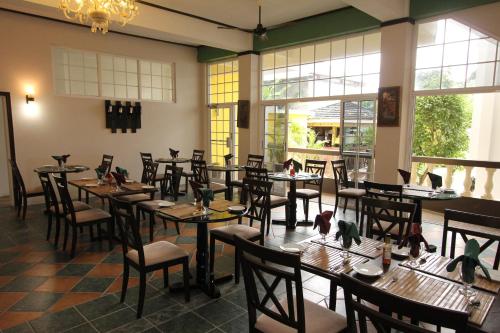 a dining room with tables and chairs and windows at Match Resort in Port Antonio