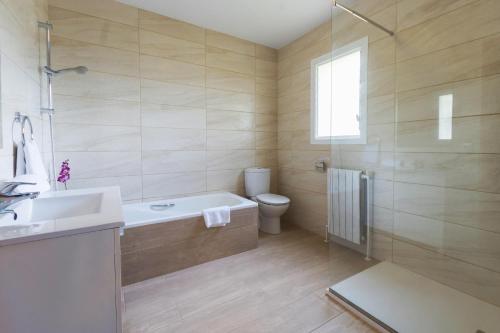 een badkamer met een bad, een toilet en een wastafel bij Jasmin in Jávea