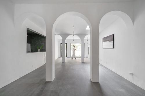 a white hallway with white walls and arches at Su Jiu Apartment in Nanning