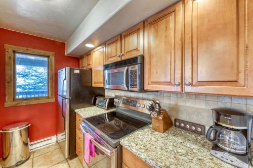 a kitchen with wooden cabinets and a stainless steel refrigerator at Timberfalls Hideaway in Vail