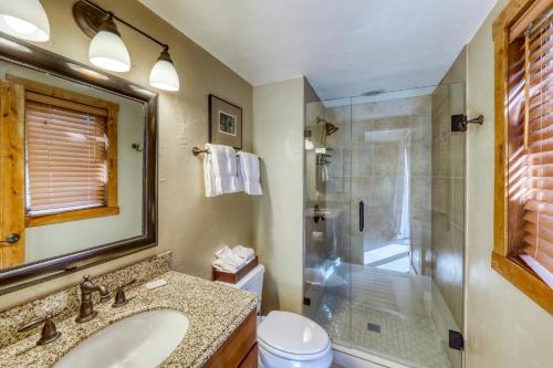 a bathroom with a shower and a sink and a mirror at Timberfalls Hideaway in Vail