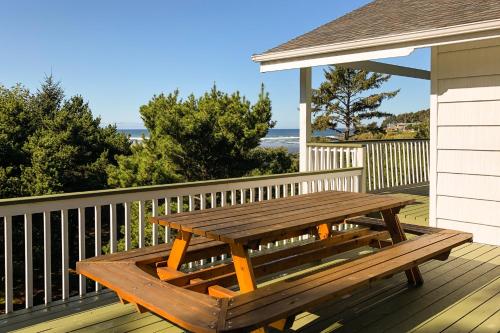 a wooden picnic table on the deck of a house at Hidden Luxury Beachfront Estate in Yachats