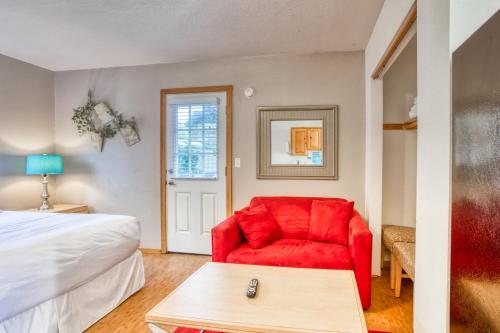 una silla roja en una habitación con cama en Beaches Inn | Pirates Cove Cabana 8, en Cannon Beach