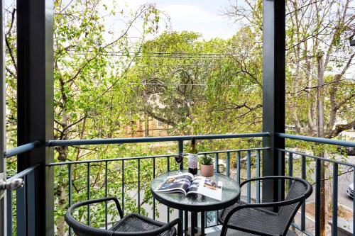 a table and chairs on a balcony with a view at Quest St Kilda Bayside in Melbourne