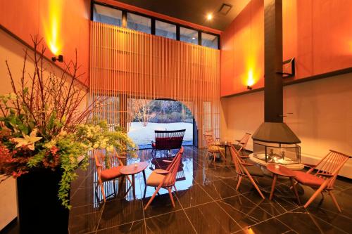 箱根町にある箱根風雅 (大人専用)のテーブルと椅子、暖炉が備わる部屋