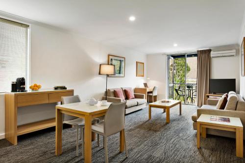 a living room with a couch and a table at Quest St Kilda Bayside in Melbourne