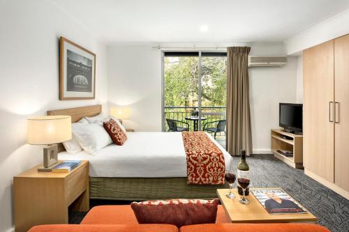 a hotel room with a bed and a balcony at Quest St Kilda Bayside in Melbourne