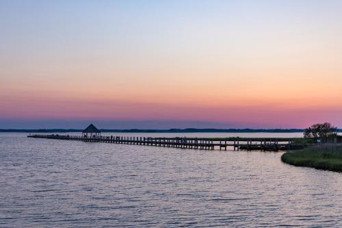a dock in the middle of the water at sunset at Ocean Place in Ocean City