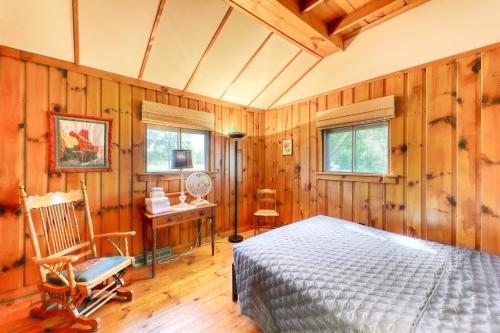 1 dormitorio con paredes de madera, 1 cama y escritorio en Thayer Beach Front Home en Colchester