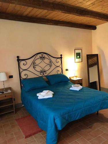 a bedroom with a blue bed with towels on it at Colle Cornetto in Spoleto
