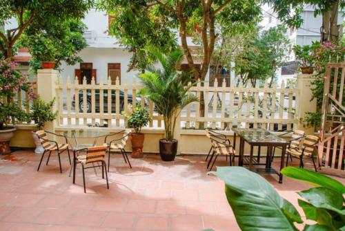 eine Terrasse mit Tischen, Stühlen und Bäumen in der Unterkunft Homestay Xuandung in Ninh Bình