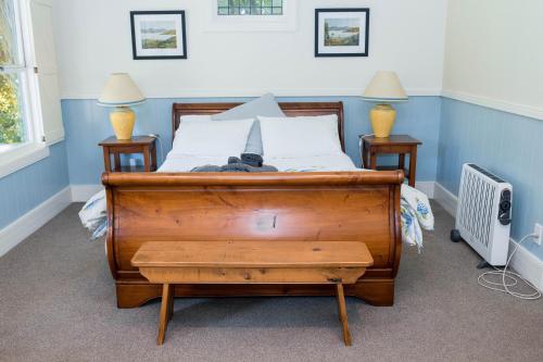 a bedroom with a wooden bed with two night stands at Akaroa Streamside Cottage in Akaroa