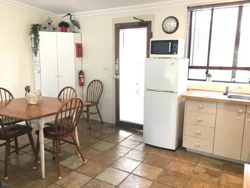 
a kitchen with a table and a refrigerator at The Apartment - Moyston in Moyston
