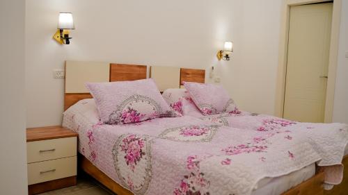 a bedroom with a bed with a pink blanket and pillows at Angel's house in Nazareth