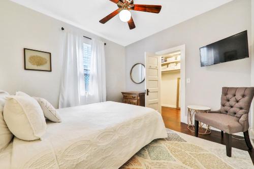 1 dormitorio con 1 cama, ventilador de techo y silla en Charming Myrtle Bungalow en St. Augustine