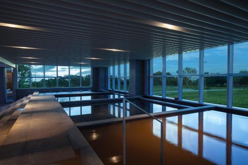 a large building with a pool of water and windows at Hotel Tops 10 in Gangneung